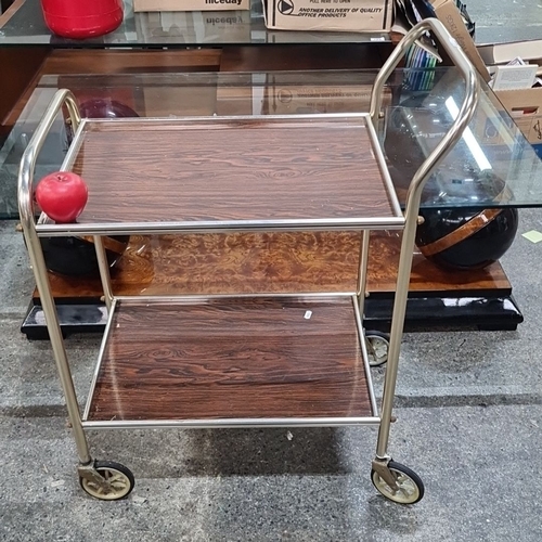 969 - Metal bar cart with faux wood shelves, tubular metal frame, and four caster wheels. Mid-Century Mode... 