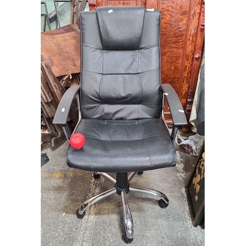 1243 - Black leather office chair with chrome base and armrests, swivel functionality, and castor wheels.
P... 