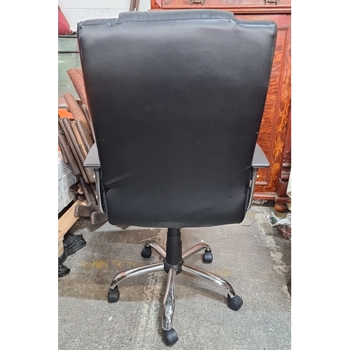 1243 - Black leather office chair with chrome base and armrests, swivel functionality, and castor wheels.
P... 