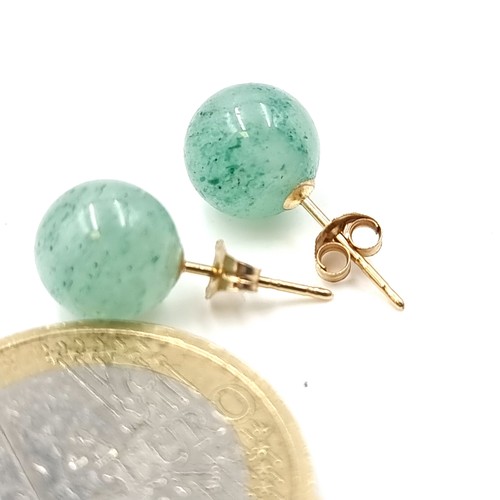 35 - A pair of 14 carat circular jade stone stud earrings. Weight - 2 grams.