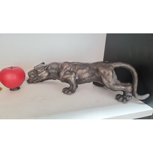 400 - A heavy cast metal figure of a panther in a dynamic pose.