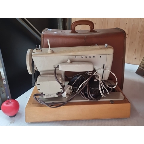 414 - Vintage Singer sewing machine with brown carrying case, pedal, and various attachments. Classic mech... 