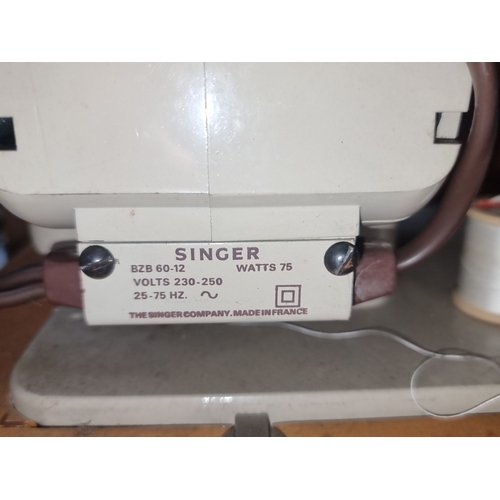 414 - Vintage Singer sewing machine with brown carrying case, pedal, and various attachments. Classic mech... 