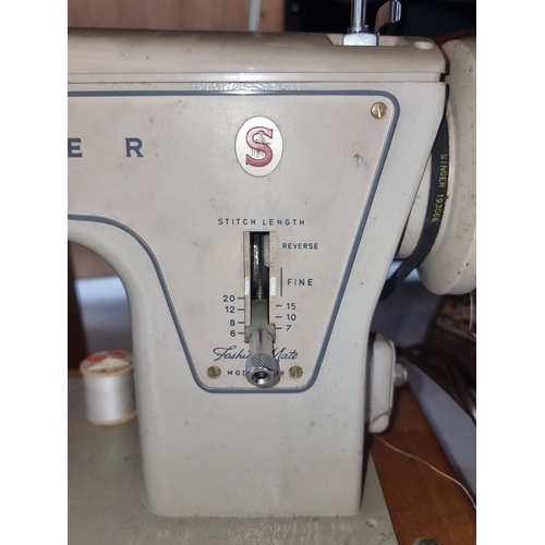 414 - Vintage Singer sewing machine with brown carrying case, pedal, and various attachments. Classic mech... 