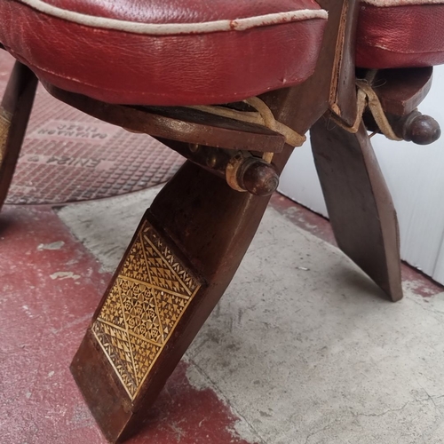 415 - Vintage red leather upholstered footstool with detailed wooden inlay. Features intricate geometric p... 