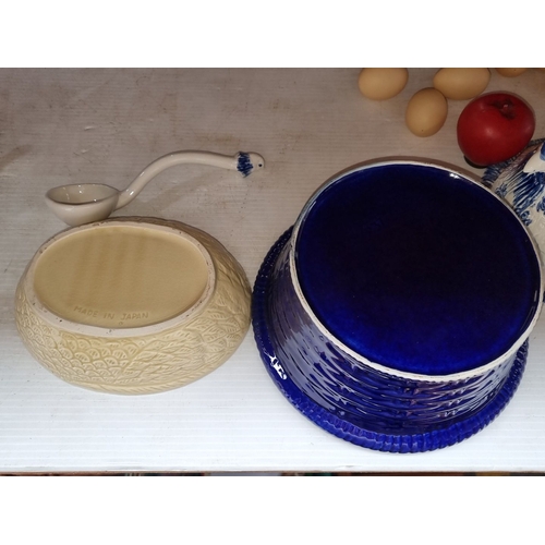 434 - Two ceramic hen-shaped lidded dishes; one with blue floral patterns, the other cream-colored with br... 