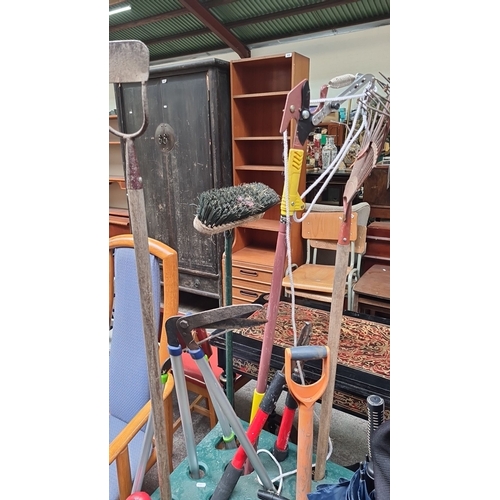 470 - Mixed lot of assorted garden tools, including rakes, brooms, hedge shears, and pruning shears in a  ... 