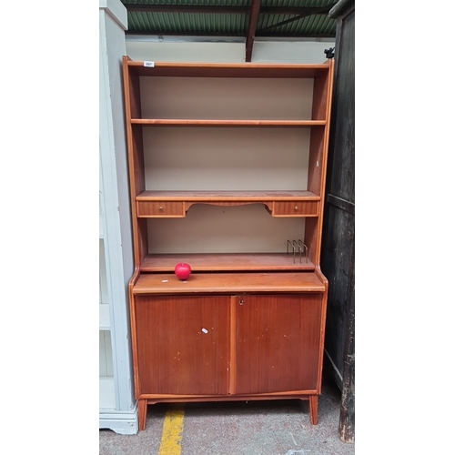 497 - Star Lot : Mid-Century Modern wooden bookcase with cupboard. Features two shelves, two drawers, and ... 