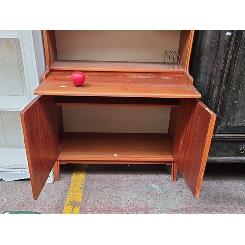 497 - Star Lot : Mid-Century Modern wooden bookcase with cupboard. Features two shelves, two drawers, and ... 