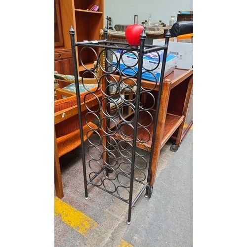 474 - Vintage wrought iron wine rack stand features a classic design with circular holders and accommodate... 