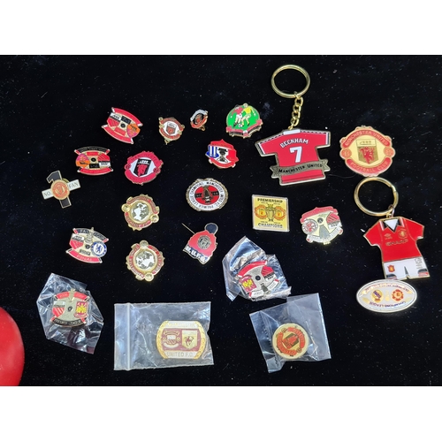 103 - A collection of Manchester United Football Club pins and badges. Also includes Beckham jersey key ri... 