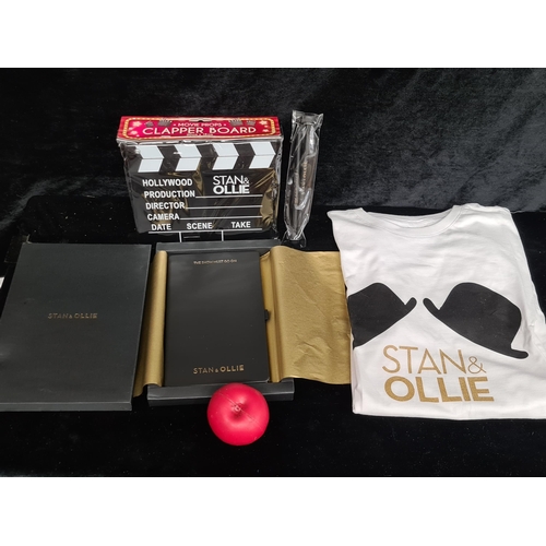 207 - A mixed lot of Laurel and Hardy memorabilia including a t-shirt, boxed diary and a clapper board.