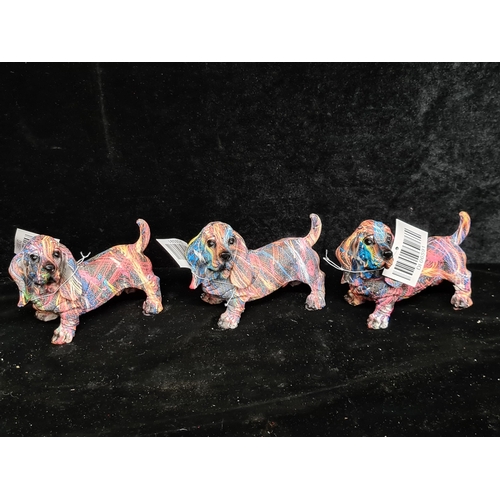 280 - A box containing three adorable and colorful basset hound dog figures. These are all brand new but a... 