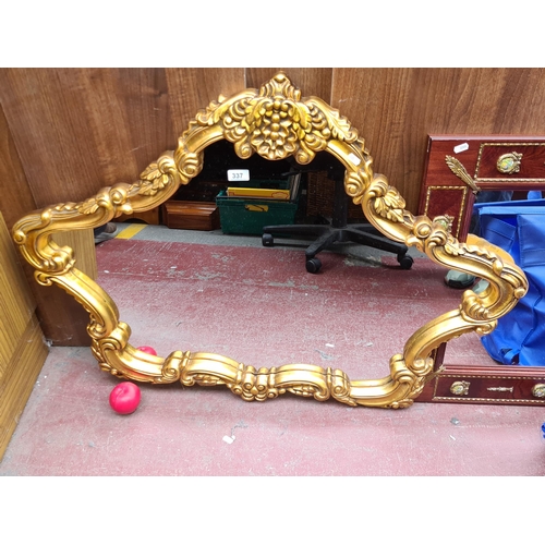 337 - Star Lot : A French Oval mirror. Features rococo style. Housed in a decorative gilt frame.