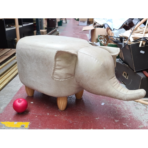 382 - A charming large vegan leather Elephant Footstool. with wooden legs and long trunk. Brand new from a... 