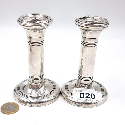 20 - A pair of sterling silver weighted candle sticks with hallmarks for Birmingham dating to 1910. Total... 