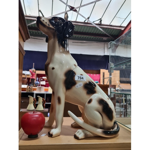 704 - A large ceramic figure of a posed dog.