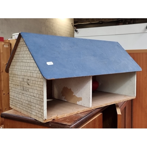 641 - Wooden dollhouse with painted brickwork and floral details, featuring a blue roof and pink exterior.... 