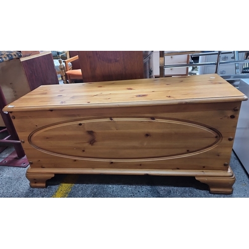 654 - Solid pine blanket chest with hinged lid and carved oval detailing. Measures approximately 40 inches... 