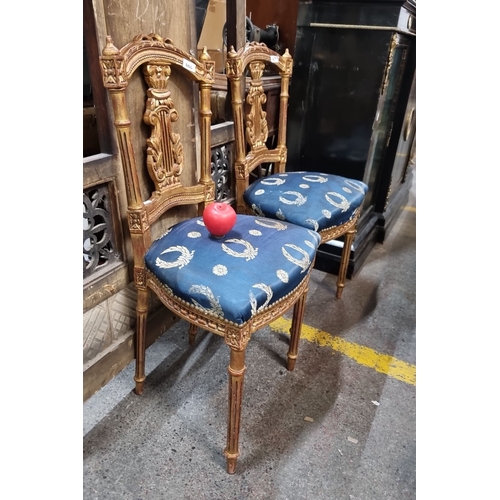 668 - Star Lot : Pair of intricately carved giltwood chairs with blue and gold patterned upholstery, from ... 