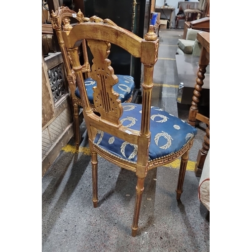 668 - Star Lot : Pair of intricately carved giltwood chairs with blue and gold patterned upholstery, from ... 