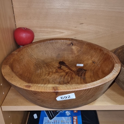 692 - Set of three wooden bowls made from solid wood with visible grain patterns, varying in color from li... 