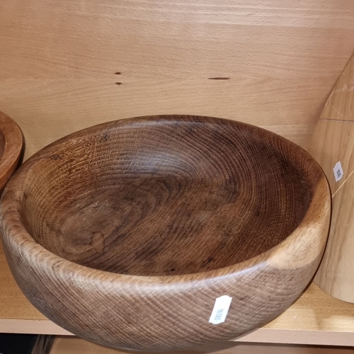 692 - Set of three wooden bowls made from solid wood with visible grain patterns, varying in color from li... 