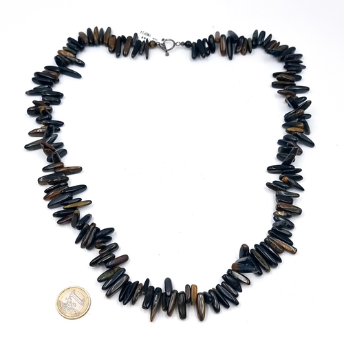 523 - An attractive blue Tigers Eye necklace with sterling silver T-bar clasp. Total weight 159.81 grams. ... 