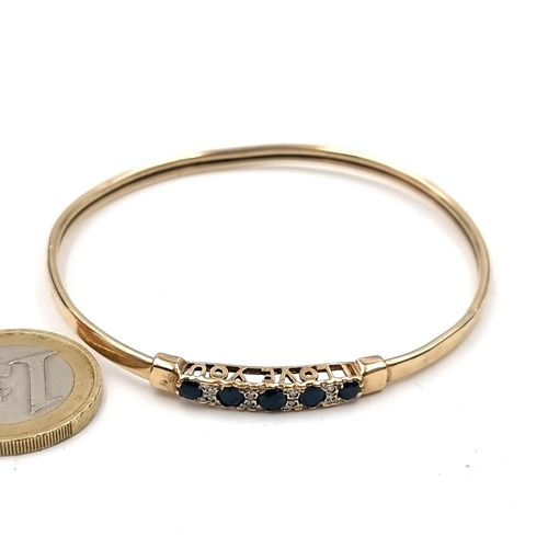 539 - Star Lot : An exquisite nine carat gold sapphire and diamond bangle with 