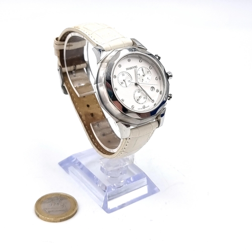 586 - A pre worn Swarovski Swiss made watch set in white dial together with a white leather strap. Comes i... 