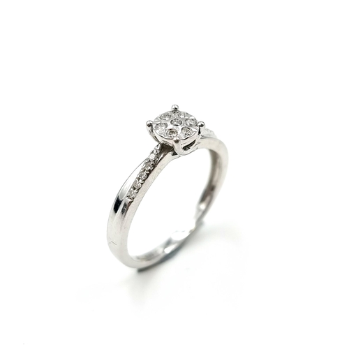 605 - Star Lot : A truly stunning nine carat white gold diamond ring. Round diamond halo like cluster with... 