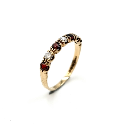 606 - A very pretty garnet and gemstone ring set in nine carat gold. Size P1/2. Weight 1.60 grams. Boxed.