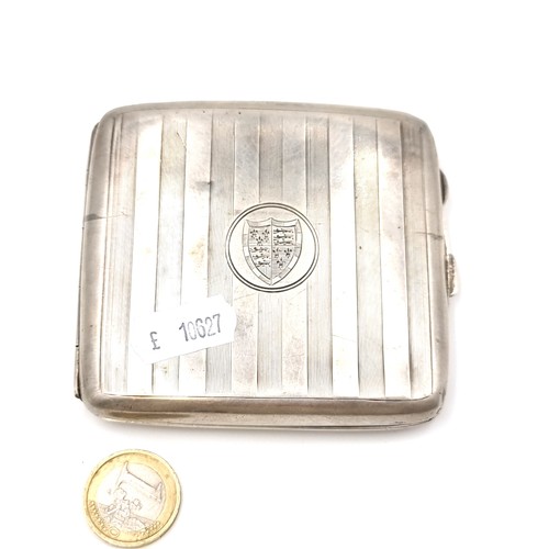 620 - An antique sterling silver machine cut hip cigarette case with crest to front and hallmarks for Birm... 