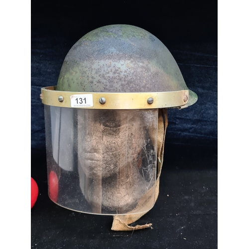 131 - A vintage military riot helmet with shield.