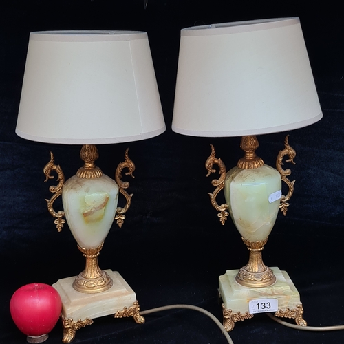 133 - A pair of vintage onyx and brass table lamps with sea serpent handles and cream shade.