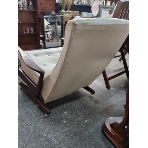 803 - Mid-Century Modern reclining chair with cream upholstery and wooden armrests, featuring a retractabl... 