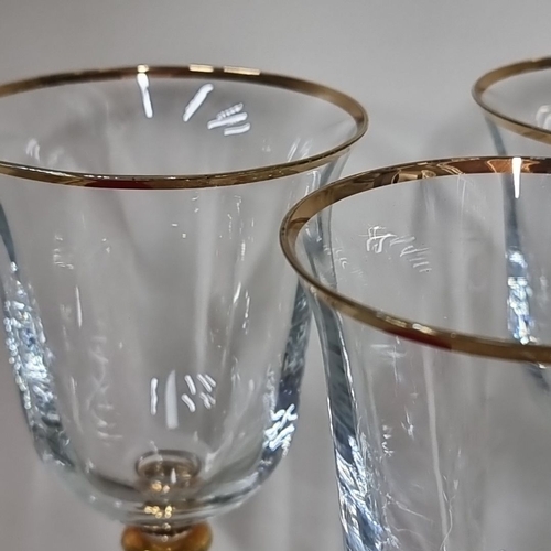 827 - Set of six crystal wine glasses featuring intricate etched design, gold rim, and gold accent on the ... 