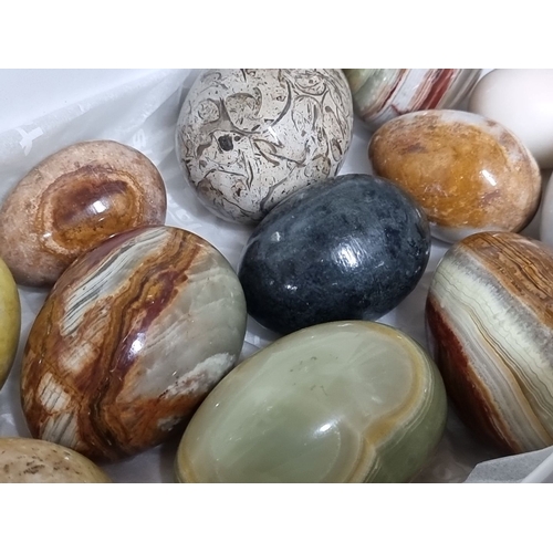 829 - Collection of twelve polished decorative stone eggs in a variety of colors and patterns. Stones incl... 