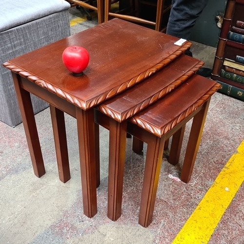 1378 - Set of three nested wooden tables with elegantly carved edges, dark mahogany finish, and classic des... 