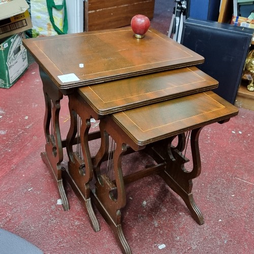 325 - A gorgeous set of three mahogany nesting tables standing on elegant harp shape supports, making them... 