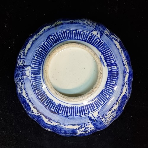 153 - An antique Japanese blue and white porcelain bowl having 
 ribbed form with scalloped rim. Lots of n... 