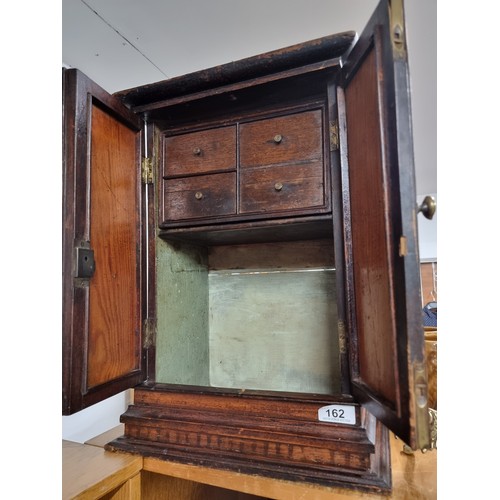 162 - A fantastic antique hand carved mahogany medicine cabinet featuring double doors to front, brass han... 