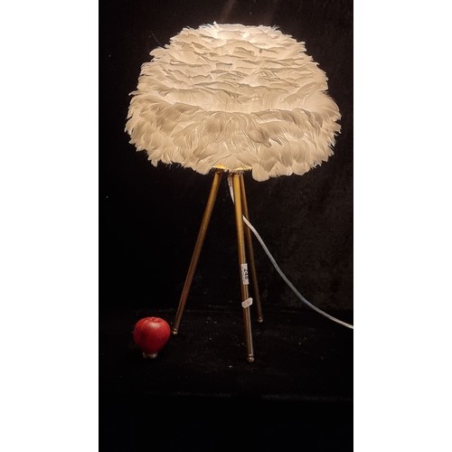 248 - A white feather table lamp on brushed brass tripod base. With original instructions for use and plug... 