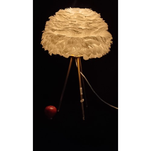 248 - A white feather table lamp on brushed brass tripod base. With original instructions for use and plug... 