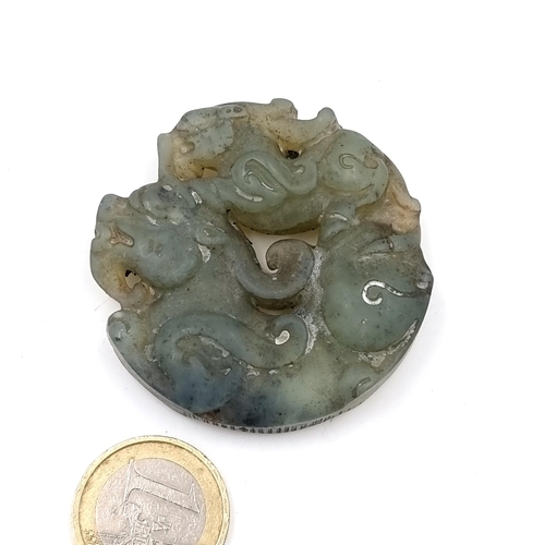 23 - An antique Chinese carved jade medallion.