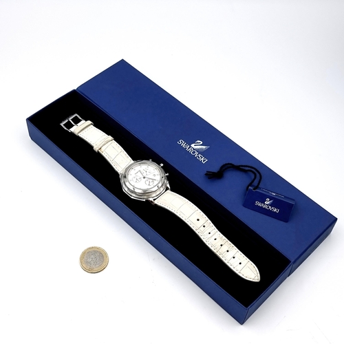 586 - A pre worn Swarovski Swiss made watch set in white dial together with a white leather strap. Comes i... 