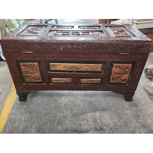 765 - A wonderful Chinese carved camphor wood chest with red lacquer.