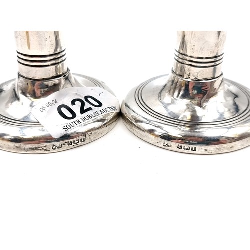 20 - A pair of sterling silver weighted candle sticks with hallmarks for Birmingham dating to 1910. Total... 