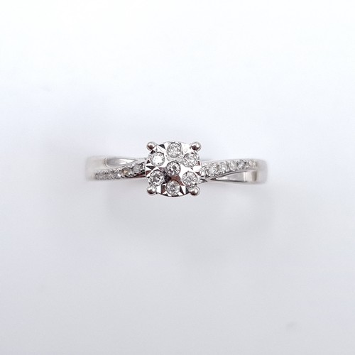 605 - Star Lot : A truly stunning nine carat white gold diamond ring. Round diamond halo like cluster with... 