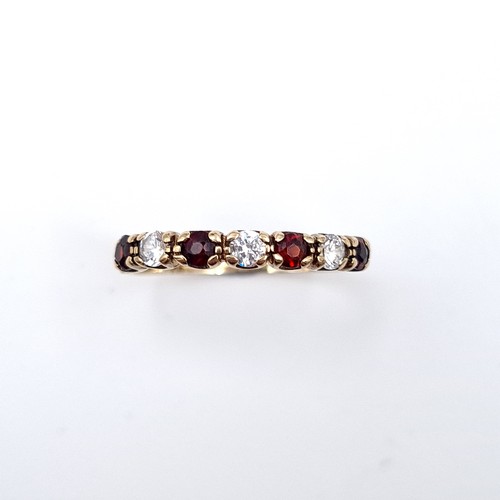 606 - A very pretty garnet and gemstone ring set in nine carat gold. Size P1/2. Weight 1.60 grams. Boxed.